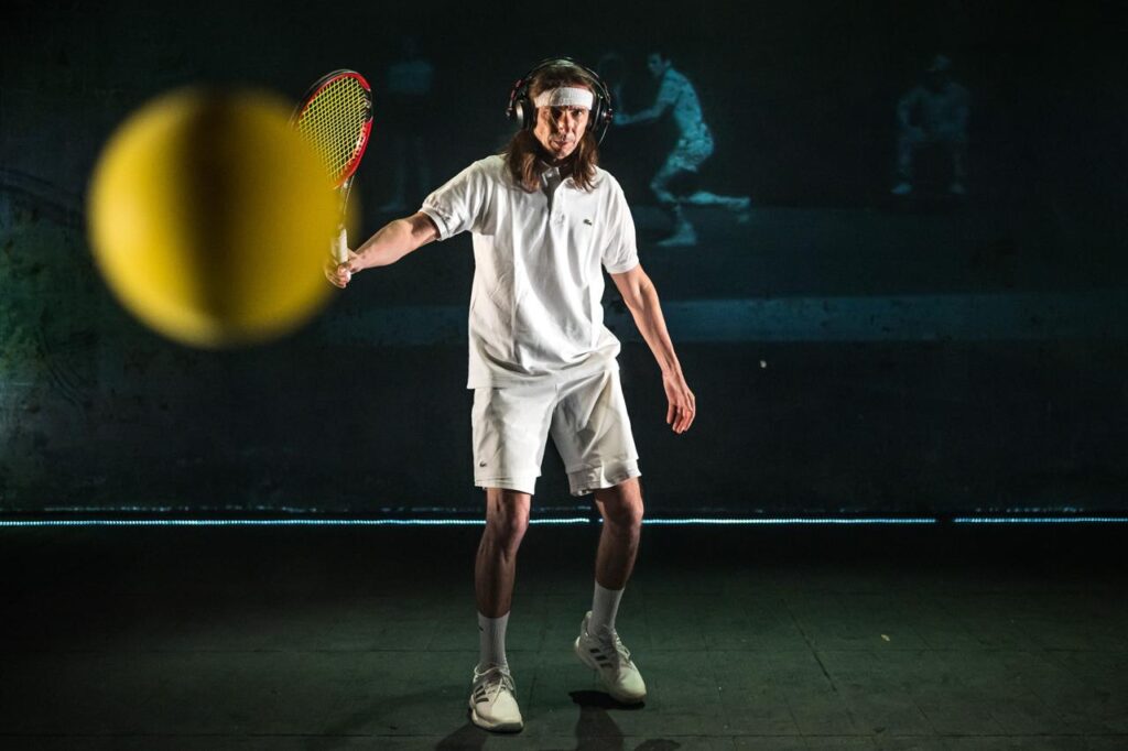 Foto del regista teatrale Paolo Valerio in scena mentre interpreta un tennista